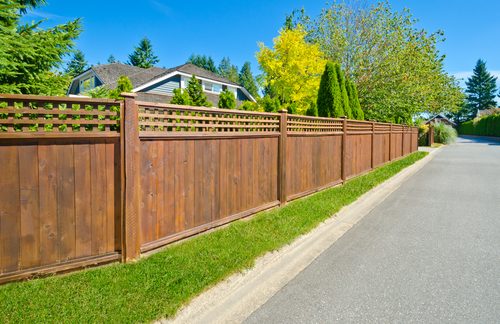Fence replacement in Greer, SC with a new stained wood fence rebuilt along a half acre subdivision line