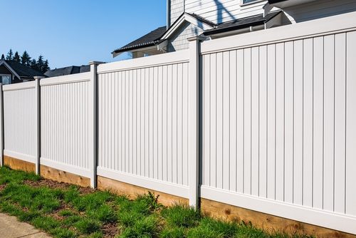 Fence replacement in Simpsonville, SC with a new white vinyl fence rebuilt on the original subdivision line